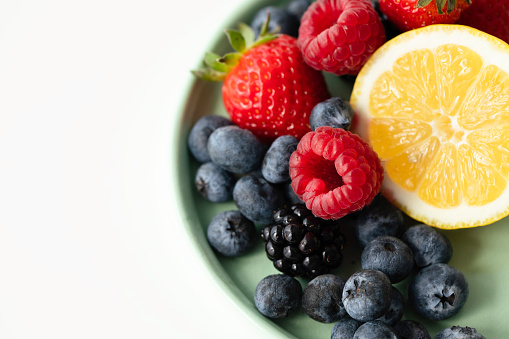 Many different berries in the form of a frame on a white background.