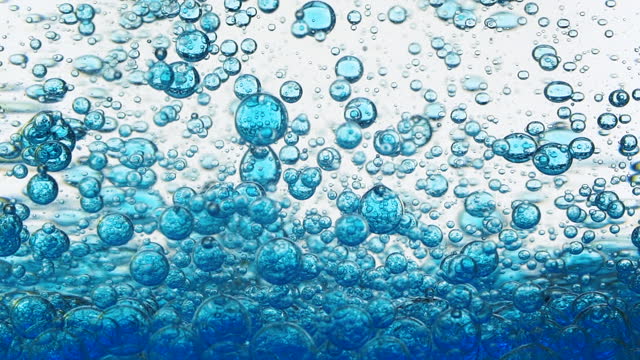 Slow motion of blue cosmetic micellar oil with bubbles