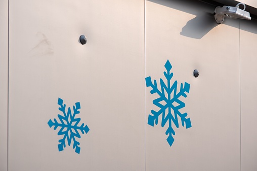 A white wall featuring a painted mural of blue snowflakes.