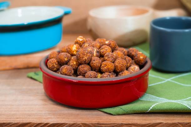 Ceramic bowl with chocolate cereal. Cocoa flavored wheat cereal. Chocolate balls. Breakfast on a wooden table.