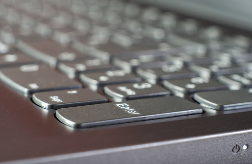 Macro photograph of a computer keyboard. Selective focus of the Enter key.