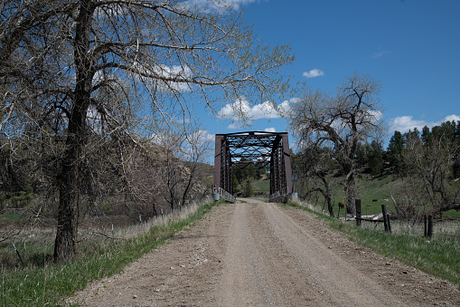 Old dirt road wooden and steel bridge over the Musselshell River in central Montana.