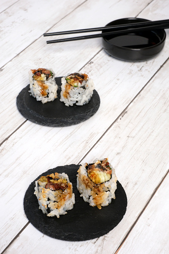 Maki sushi rolls isolated on wooden background.