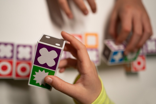 Family Table game. Strategic. Kids hands playing . Victory. Selective focus. Close-up.