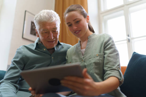 istock Senior man with his granddaughter using digital tablet. 1493826950