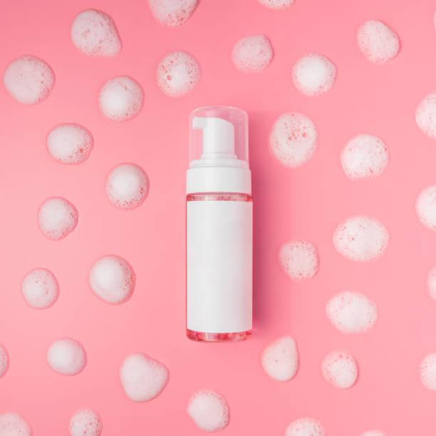 istock Bottle with foam for washing on a pink front, around a drop of foam 1493829844