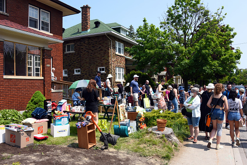 Ottawa, Canada - May 27, 2023: A huge crowd of people browse for deals at the annual Glebe neighborhood garage sale which takes place for several blocks in the Glebe area of Ottawa, Ontario.