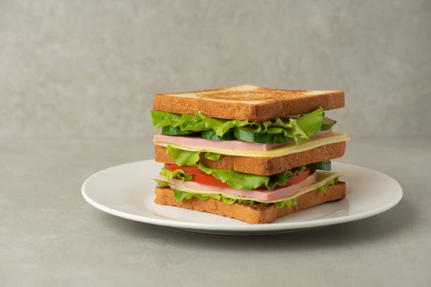 istock sandwich with meat, cheese and vegetables on a gray background 1493833556