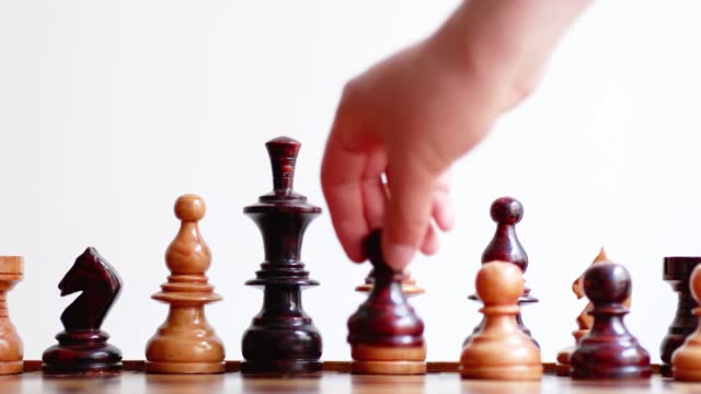 Hand puts chess pieces of different colors on the same team, equal treatment and opportunity message, horizontal video