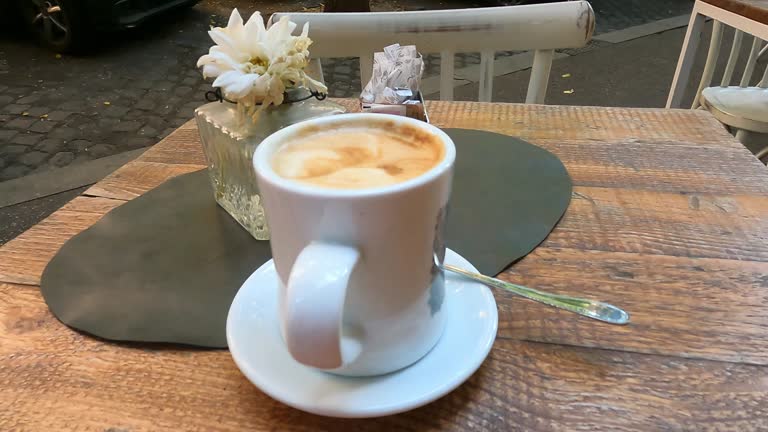 A morning coffee in a white mug on a distressed wooden table