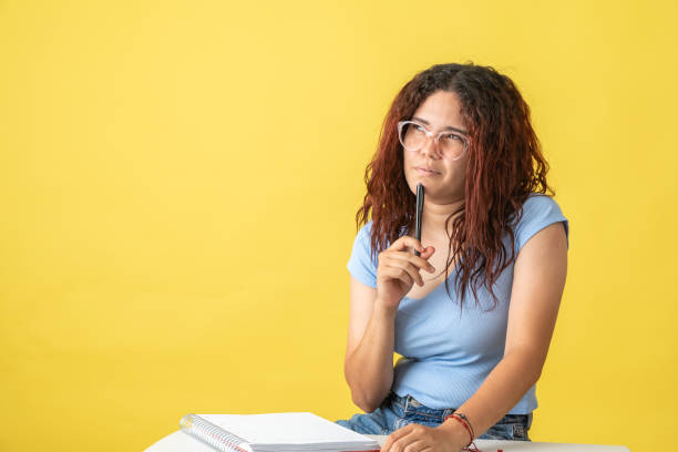 istock Young woman thinking what to write in her notebook 1493840881