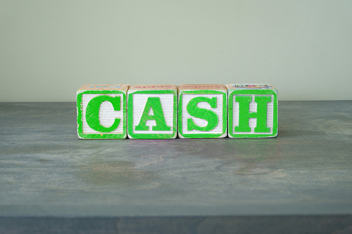 Colorful toy wooden blocks spelling out the word CASH