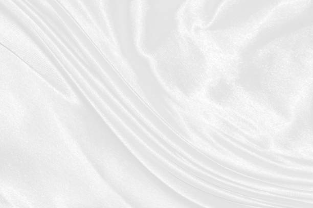 istock white silk textured cloth background,Closeup of rippled satin fabric with soft waves. 1493845932