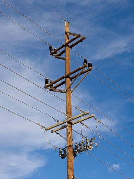 istock Power line and telephone line pole against cloudscape with blue background 1493850627