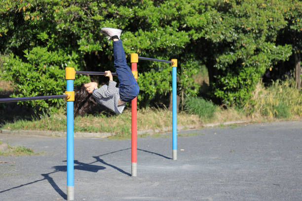 Japanese student girl playing with high bar (8 years old) Japanese student girl playing with high bar (8 years old) horizontal bar stock pictures, royalty-free photos & images