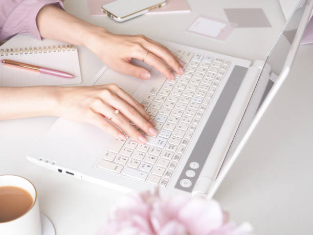 istock Female hand using laptop at desk, cute female workspace, office, work from home concept 1493858159