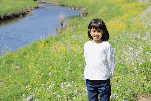 Japanese student girl standing on riverside (8 years old)