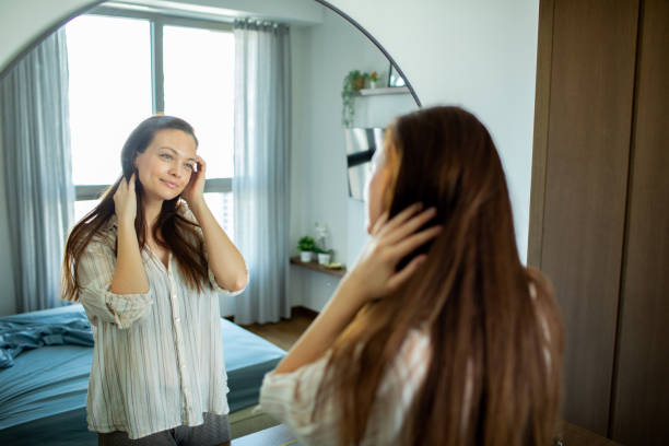 istock Young woman looking at a mirror at home 1493863697
