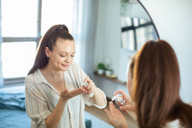 istock Young woman putting on makeup while looking in a mirror at home 1493864406