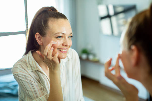 istock Young woman putting on makeup while looking in a mirror at home 1493864534