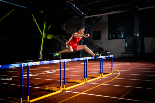 istock Athlete jumping through hurdle at night 1493865047
