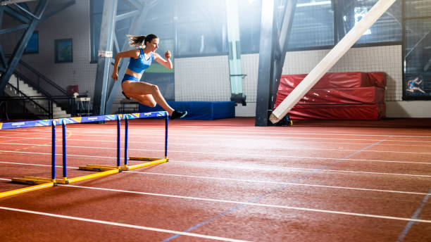 istock Sportswoman running and jumping through hurdle 1493865055