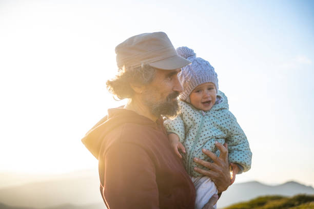 istock Dad with kid hiking in nature at sunset. 1493866584