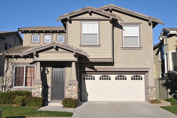 Beige two-story single family home with garage and driveway stock photo