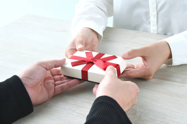 istock Male and female hands with present box 1493879163