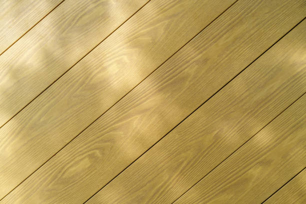 Sunlight streams across a pine floor in a domestic environment, creating an abstract background image with ample space for copy