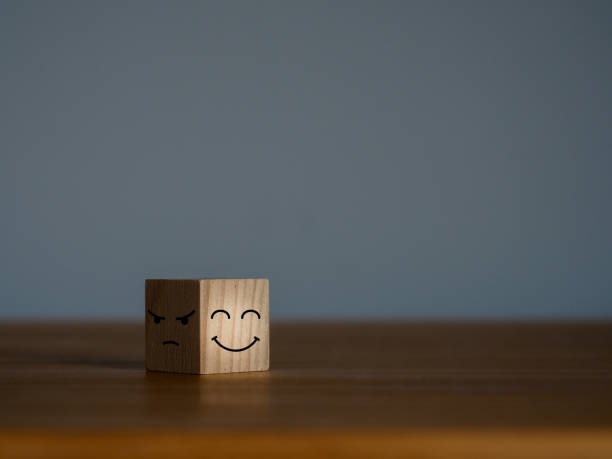istock Smiling and sad faces in the dark on wooden cubes 1493891345