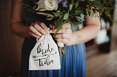 Bridesmaid holding a bag and flowers before a wedding