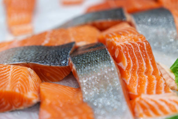 крупный план свежего сырого лосося, рыбного филе и стейков выставлен на колотом льду в розничной торговле. - freshness seafood crushed ice salmon стоковые фото и изображения