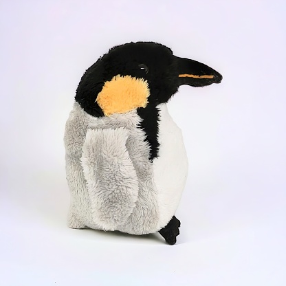 Stuffed penguin animal in black and gray on a white background
