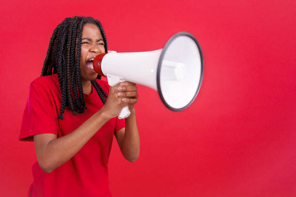 istock Angry african woman standing and using a megaphone 1493898125