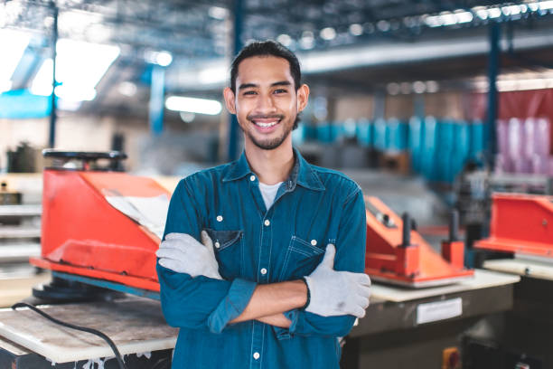 istock Factory asian man Worker using  and working industry engineers partner looking at camera and smile in factory.Engineer man wearing safety helmet working and checking machine. 1493899353