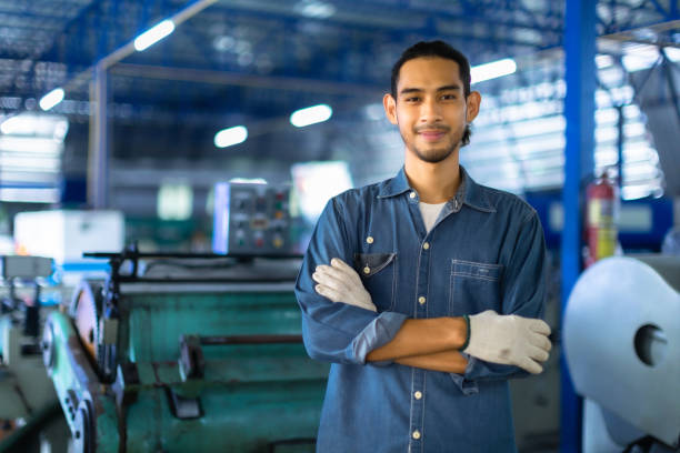 istock Factory asian man Worker using  and working industry engineers partner looking at camera and smile in factory.Engineer man wearing safety helmet working and checking machine. 1493899381