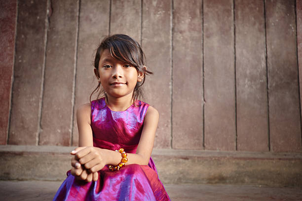 Little girl in a pink party dress posing outside for a photo Portrait of cute Asian female child in pink dress looking at camera. Copy space cambodian ethnicity stock pictures, royalty-free photos & images