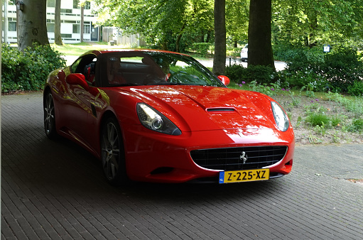 Amersfoort, Netherlands - May 21 2023 A red Ferrari F12 Berlinetta stands in front of a hotel in the Netherlands.