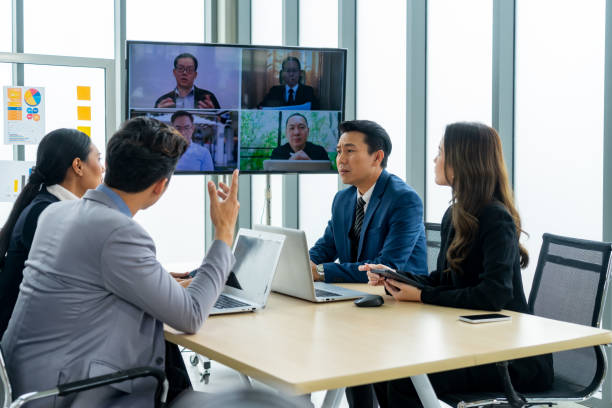 istock Executive business teamwork conference call to colleagues using technology online video chat on-screen monitor in a meeting room 1493908031