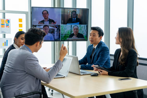 istock Executive business teamwork conference call to colleagues using technology online video chat on-screen monitor in a meeting room 1493908035