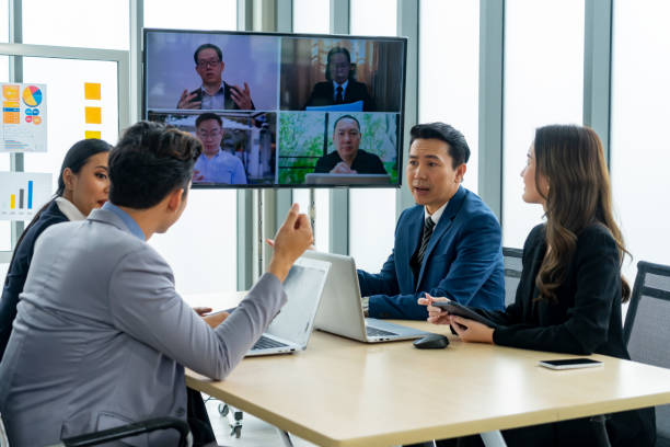 istock Executive business teamwork conference call to colleagues using technology online video chat on-screen monitor in a meeting room 1493908638