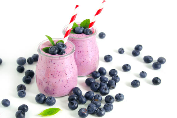 istock Two glasses of blueberry smoothie on white background. Selective focus 1493915816