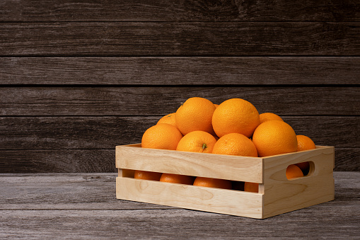 Orange fruit  in wooden crate isolated on wooden table background