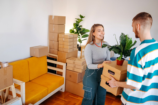 Happy young people moving boxes in their new apartment