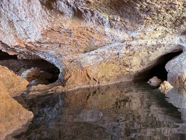 istock Cave grotto cavern with surreal rocks reflections in underground river water. 1493922517