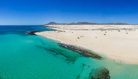Beautiful high aspect aerial panoramic view of the white sandy beach of Playa del Dormidero near Corralejo in Fuerteventura Canary Islands Spain