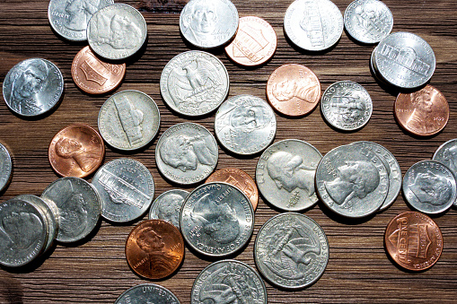 American coins placed on a dark wooden table capturing the essence of financial transactions, savings or investment concepts.