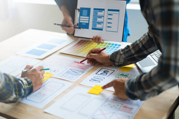 istock Close up view of UI developer team brainstorming on their project with laptop, smartphone and digital tablet. Creative digital development agency. 1493936610
