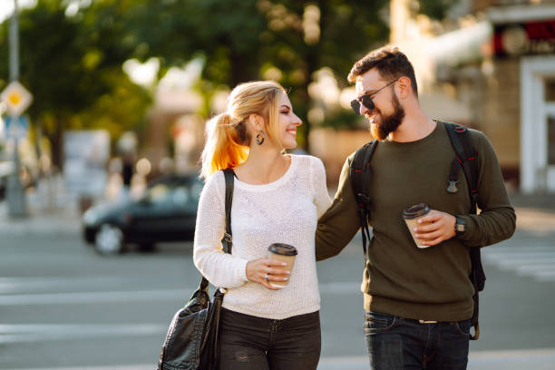 Stylish couple in love outdoors and drinking coffee.